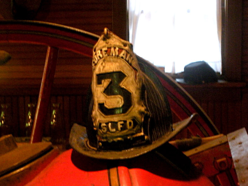 Old helmets from different fire departments are scattered around the displays. Photo: B. Miskin