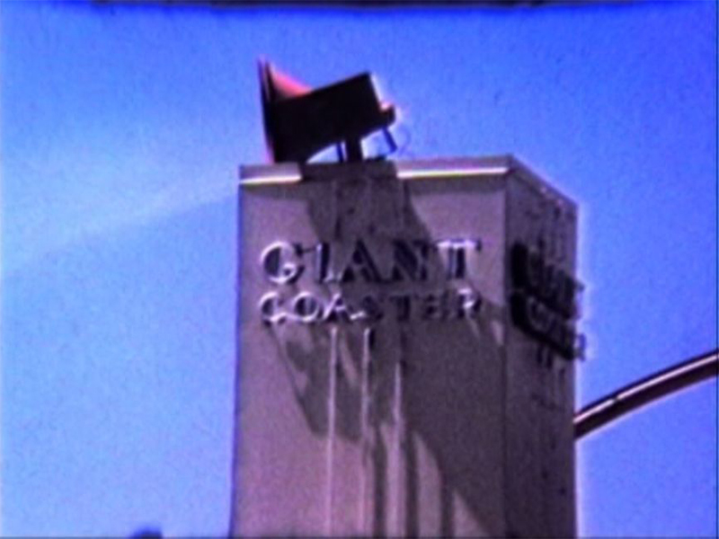 Close-up of the neon sign for the "Giant Coaster" in a film from Sharpshooter Productions.